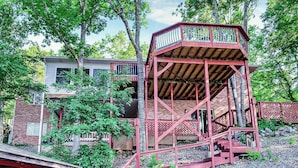 A red metal lookout tower with a wooden staircase, surrounded by trees and a brick building. - Amazing Views, Huge Game Room, Dock, Deck, Sleeps 16, Free Kayaks! (Hot Springs Village)