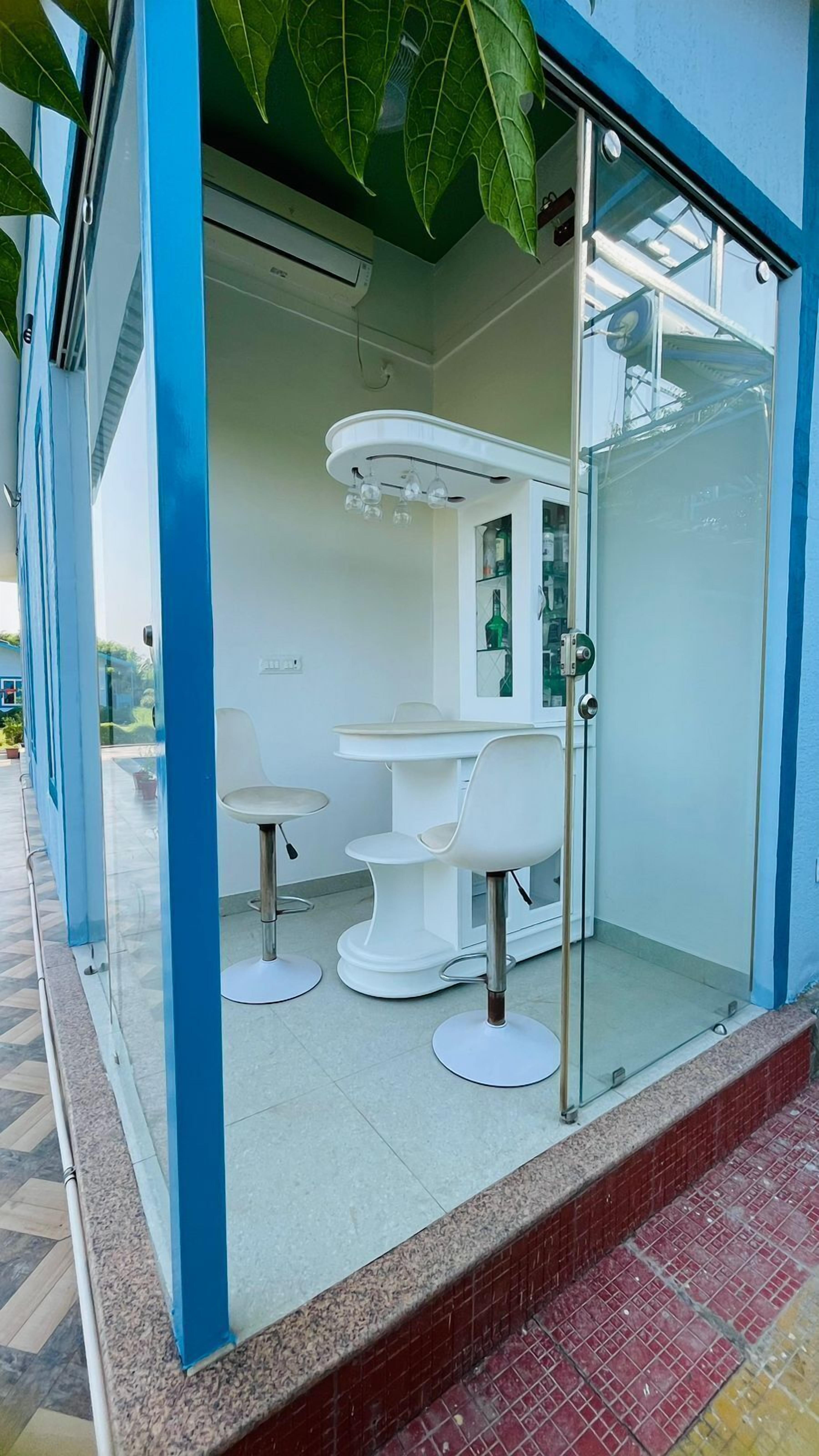 Un interior moderno con una pared de vidrio, muebles blancos y un ventilador de techo.