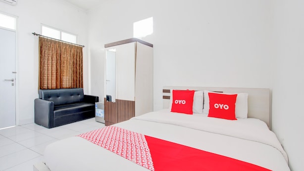 Une chambre d’hôtel avec un lit, un canapé, une armoire et un miroir.