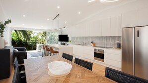 Una cocina moderna con armarios blancos, una isla grande y un horno empotrado.
