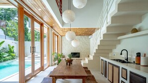 Una cocina moderna con una mesa de madera, armarios blancos y una estufa integrada.
