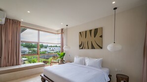 Un dormitorio moderno con una cama grande, vistas a zonas verdes y una gran obra de arte abstracta en la pared.