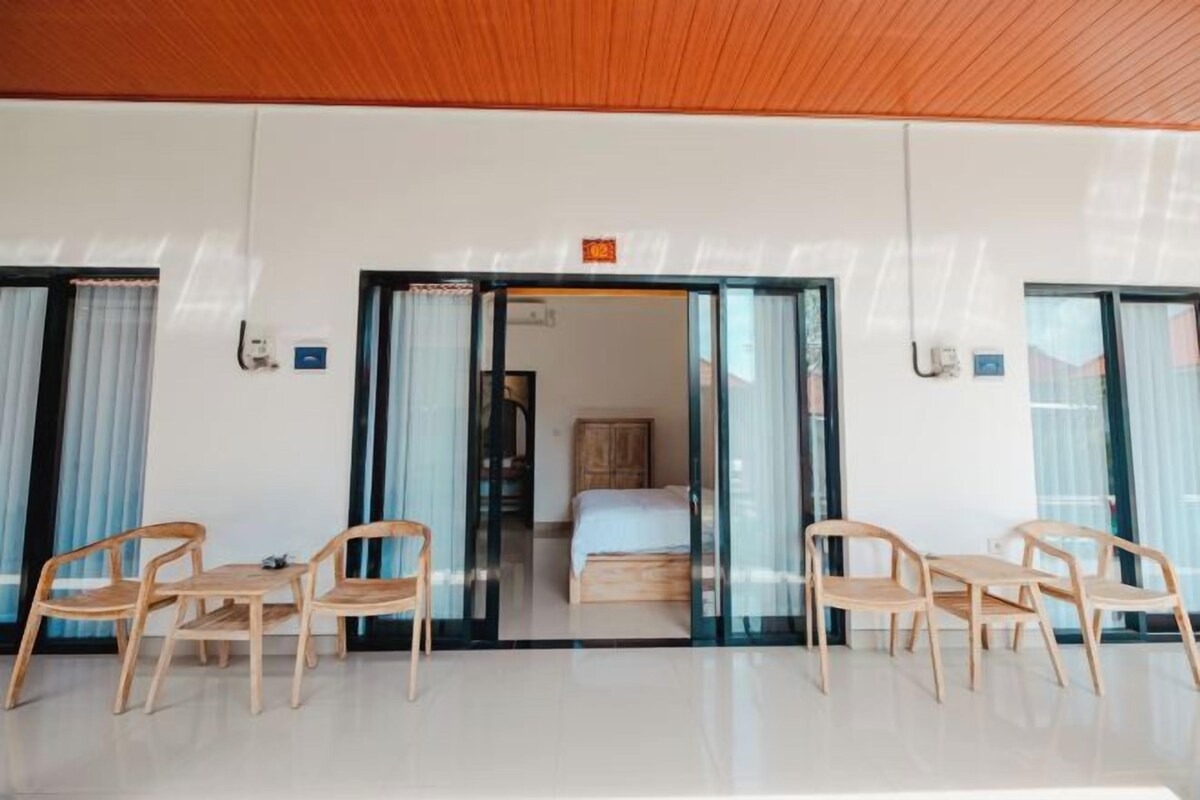 Una habitación de hotel con techo de madera, una cama, un escritorio y dos sillas.