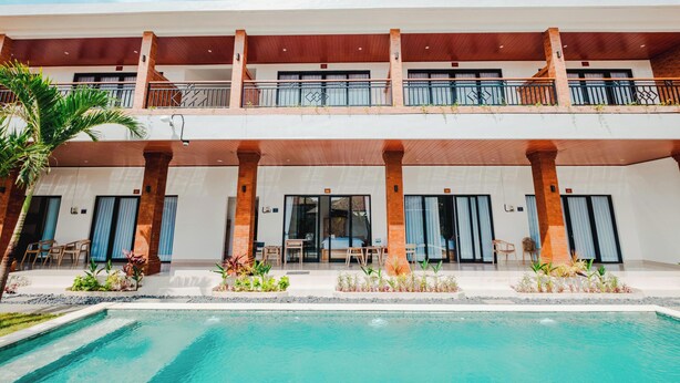 A hotel with a pool, multiple balconies, and outdoor seating areas. - Kubu Dangin Guest House Kerobokan  (Keroboken Kelod)