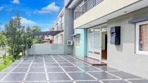 A modern residential building with a tiled patio, air conditioning units, and a balcony. - Hotel O Tangerang Near Supermall Karawaci  Formerly Bromo 18 (Curug)