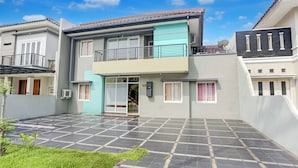 A two-story residential building with a tiled courtyard, a balcony, and a satellite dish. - Hotel O Tangerang Near Supermall Karawaci  Formerly Bromo 18 (Curug)