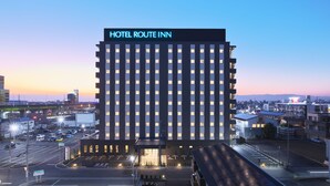 A modern hotel with a grid of windows and a prominent sign reading "HOTEL ROUTE INN".