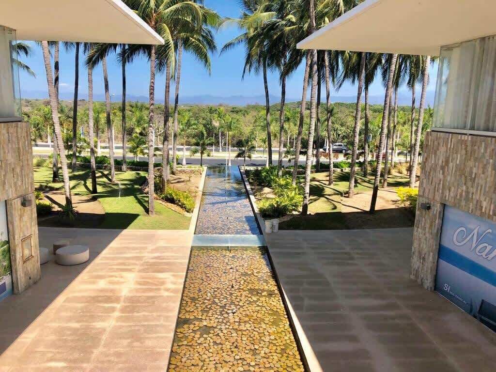 A resort with a view of palm trees and a water feature.