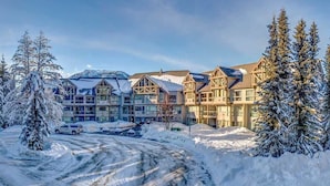 A multi-story hotel with a snow-covered landscape, featuring a mix of modern and traditional architecture.