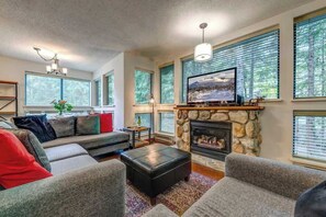 A living room with a stone fireplace, a television, and a sofa.