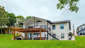 A two-story house with a covered patio, a staircase, and a well-maintained lawn. - Bluebonnet Surprise-Lakefront, Hot Tub, Boat Slip (Kingsland)