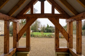 A wooden structure with a view of a green lawn and trees. - 19th Century House, Private Parking, nr Painswick (Edge)