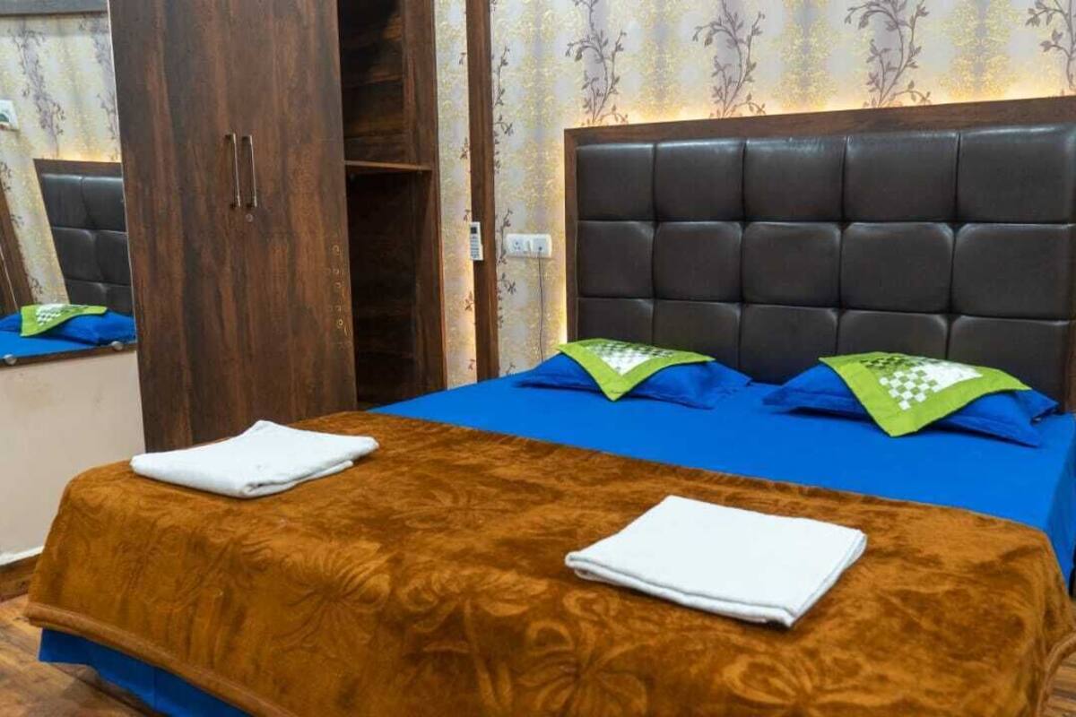 Hotellihuone, jossa on suuri sänky, vaatekaappi ja peili.