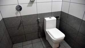 Ein modernes Badezimmer mit Toilette, Dusche und einem Händetrockner.