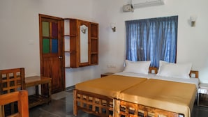 Ein Zimmer mit einem Bett, Holzmöbeln, einem Kleiderschrank und einem Fenster mit Vorhängen.