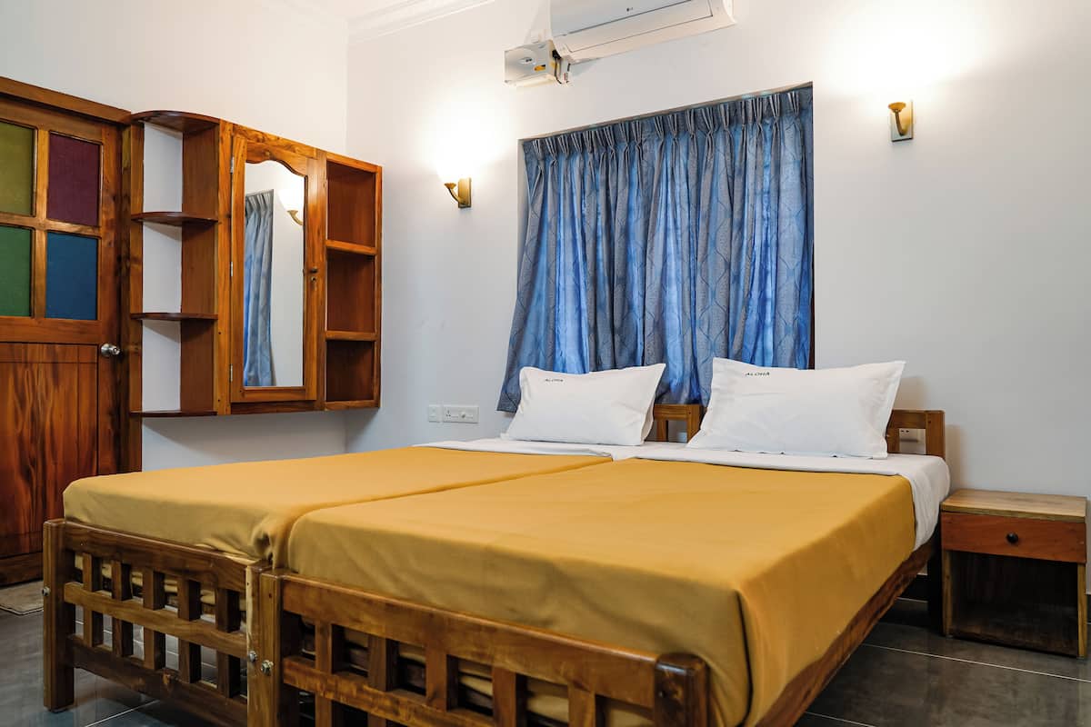 A bedroom with a wooden bed, a nightstand, a wardrobe with a mirror, and a window with blue curtains.