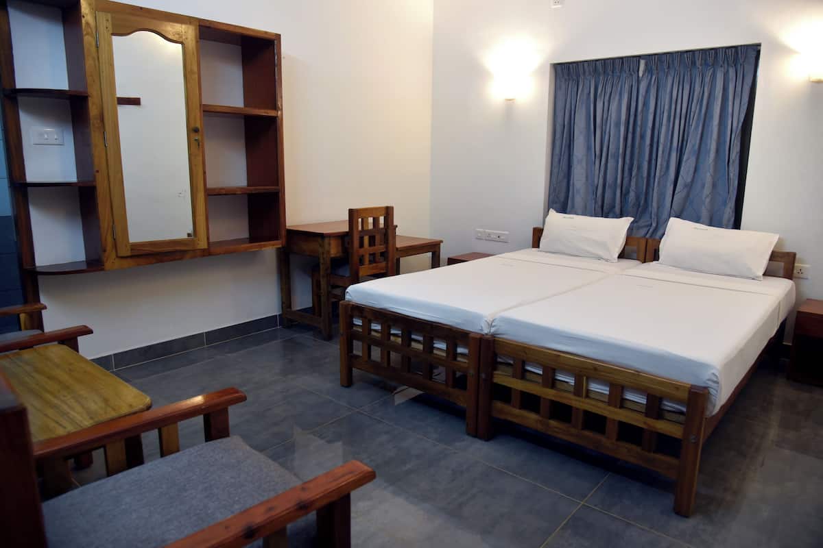 A hotel room with a wooden bed, a desk, a chair, and a mirror on the wall.