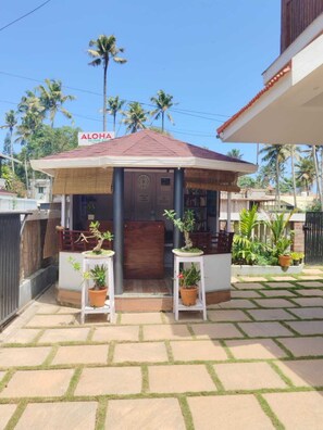 A small, covered outdoor area with a sign reading "ALOHA HOME STAY". - Aloha Homestay (Varkala)