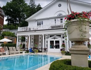 Ein Poolbereich mit Liegestühlen und einem großen Blumenbeet.