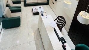 Ein modernes, gut beleuchtetes Zimmer mit einer Couch, einem Schreibtisch und einem Stuhl.