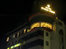 Un hotel con un letrero llamativo que dice 'HOTEL O'NEST PRIME' de noche.
