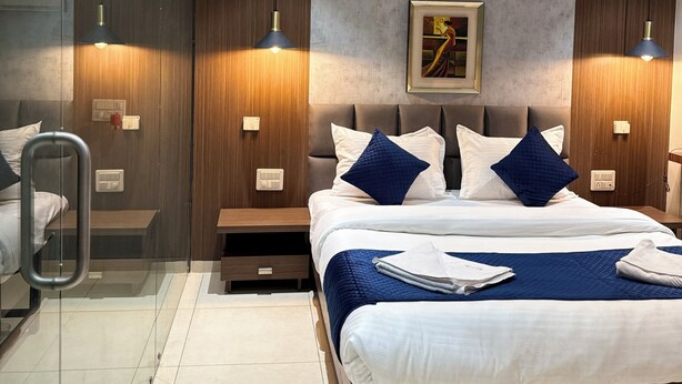 Ein modernes Hotelzimmer mit Bett, Nachttischen, Deckenventilator und einem gerahmten Kunstwerk an der Wand.