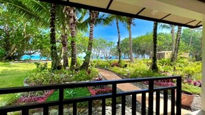 A covered outdoor area with a pathway leading to a lush garden and a view of the sea. - Dianao Beach Club and Resort (Casiguran)