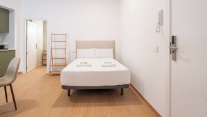 A modern hotel room with a bed, a chair, a desk, and a wardrobe. - VLC HOST- Molinell 7 (Valencia)