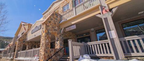 A stone building with a wooden balcony and a sign reading "KIDTOPIA HEADQUARTERS".