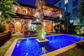A pool with a tiled pattern, surrounded by a well-maintained garden and a building with traditional architecture. - The Saharah Mirage Bali (Kuta)