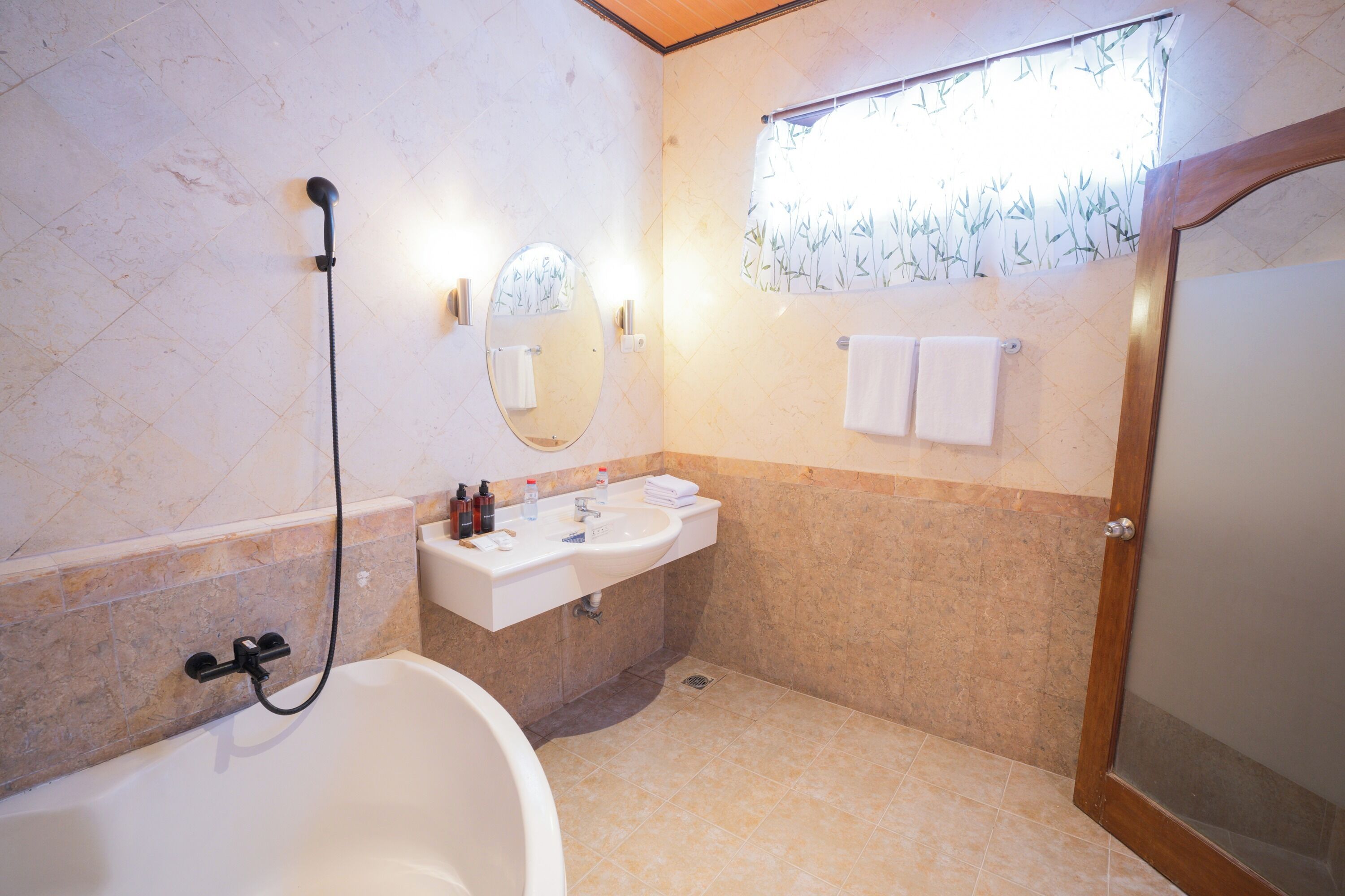 A bathroom with a bathtub, sink, mirror, and towel rack.