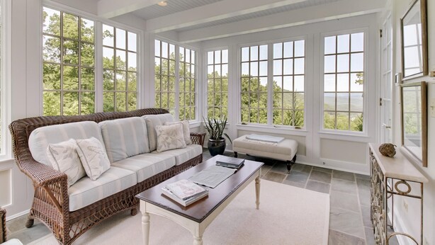 A spacious room with a large window, a wicker sofa, a small table, and a cabinet. - Luxury Home w/ Mtn Views, 1 Mile to the Homestead! (Hot Springs)