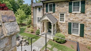 A stone house with a porch, a stone staircase, and a well-maintained garden. - Luxury Home w/ Mtn Views, 1 Mile to the Homestead! (Hot Springs)