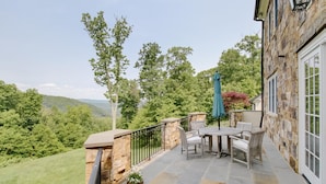 A patio with stone flooring, a table with chairs, and a potted plant. - Luxury Home w/ Mtn Views, 1 Mile to the Homestead! (Hot Springs)