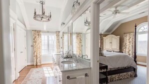 A spacious bedroom with a large bed, a vanity with a mirror, and a walk-in closet. - Luxury Home w/ Mtn Views, 1 Mile to the Homestead! (Hot Springs)