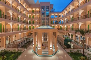 Ein mehrgeschossiges Hotel-Atrium mit einer zentralen offenen Fläche, Balkonen und Pflanzen.