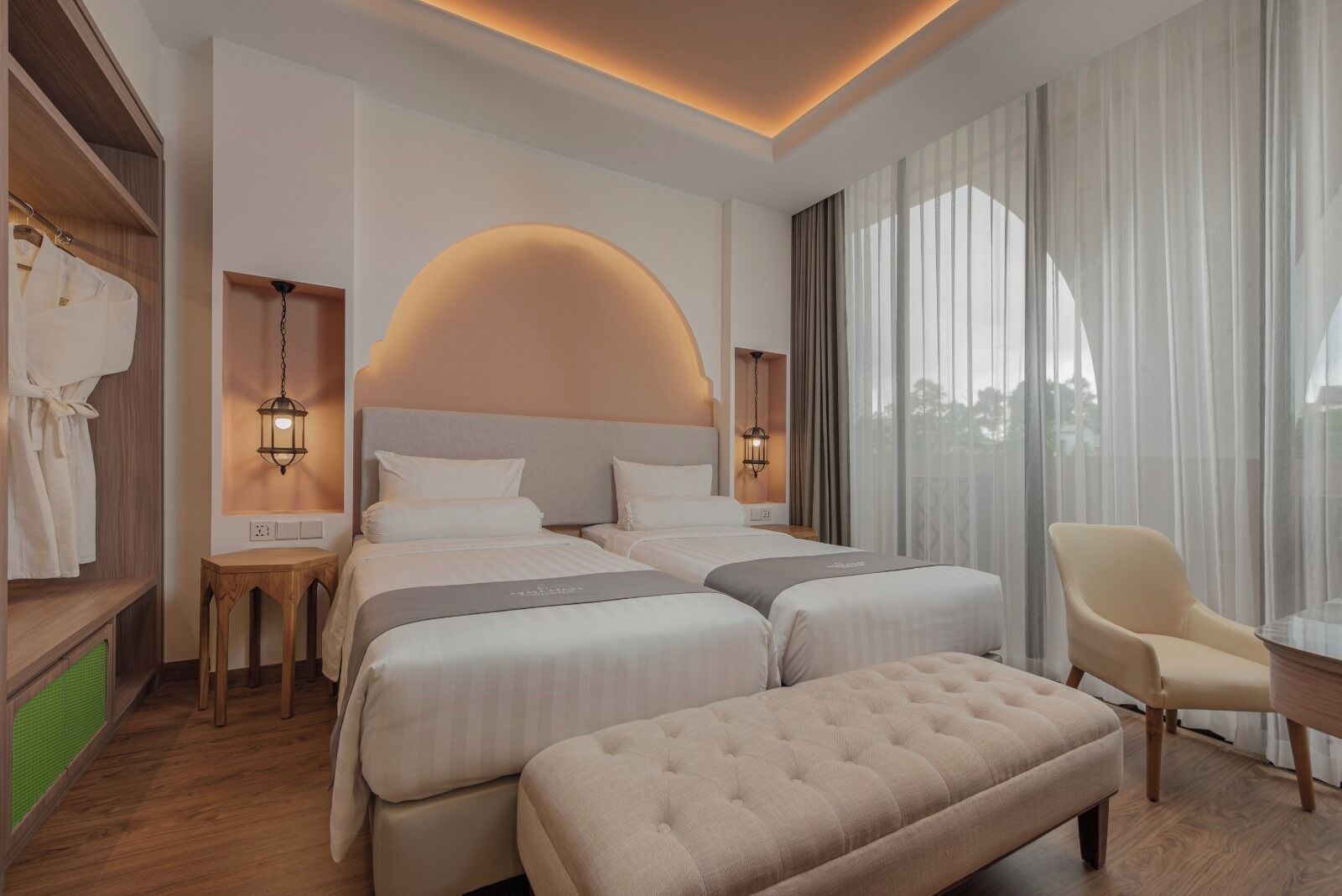 A hotel room with a large bed, two bedside tables, a chair, and a view of the outdoors.