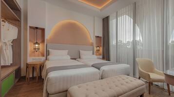 A hotel room with a large bed, two bedside tables, a chair, and a view of the outdoors.