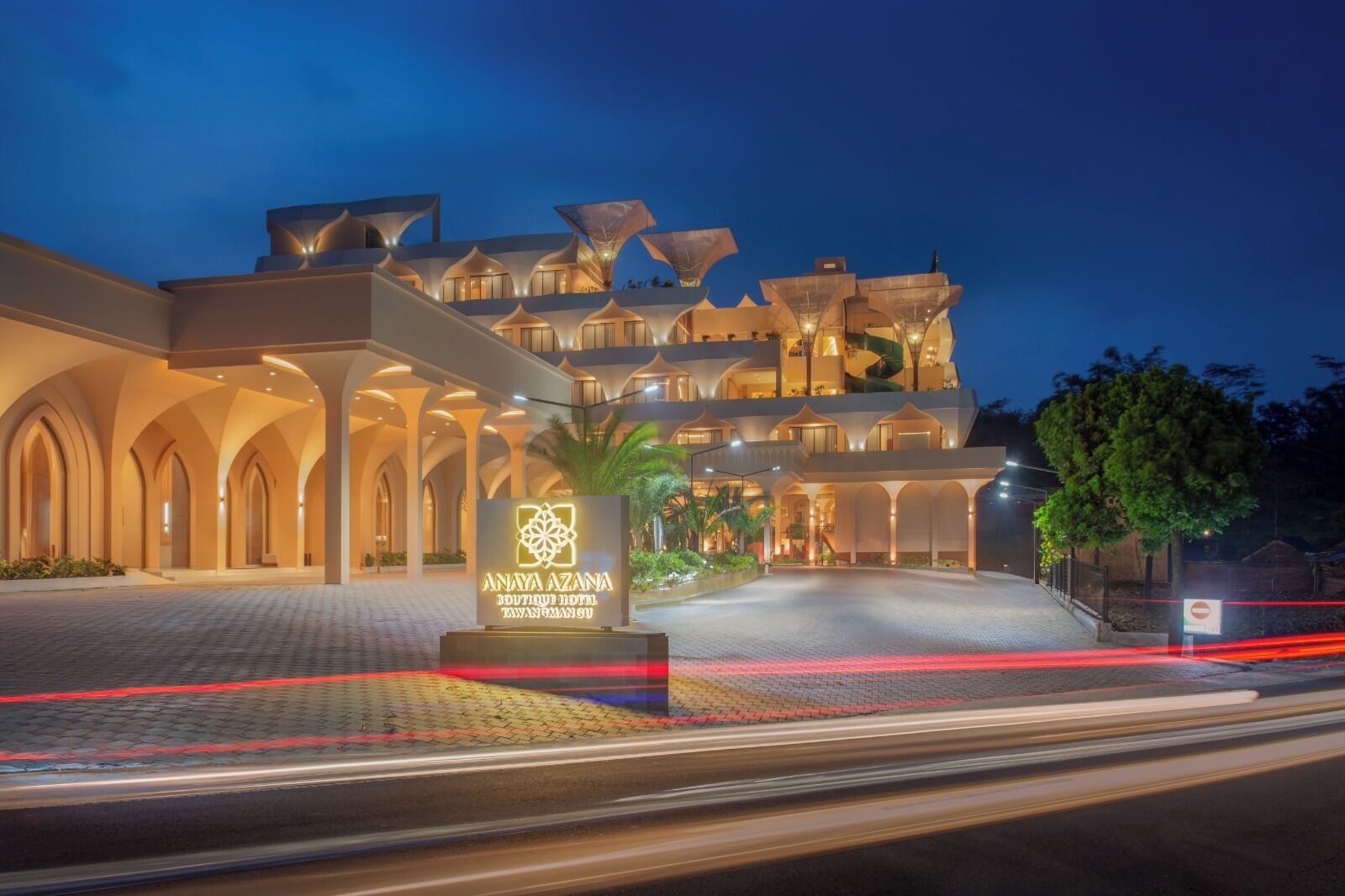 A modern hotel with a distinctive architectural design, featuring multiple levels and a prominent entrance.