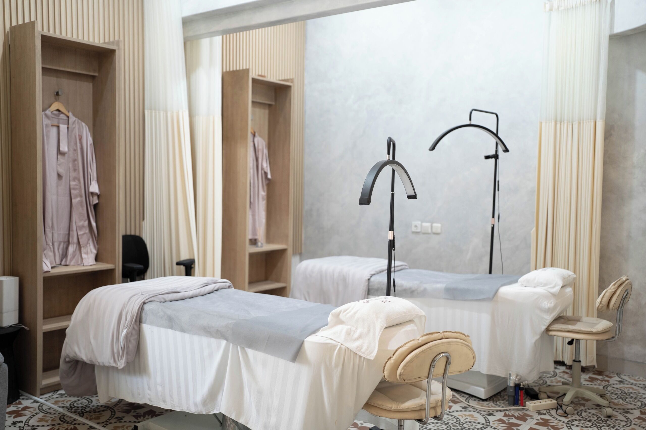 A room with two beds, a chair, a desk, and a wardrobe.