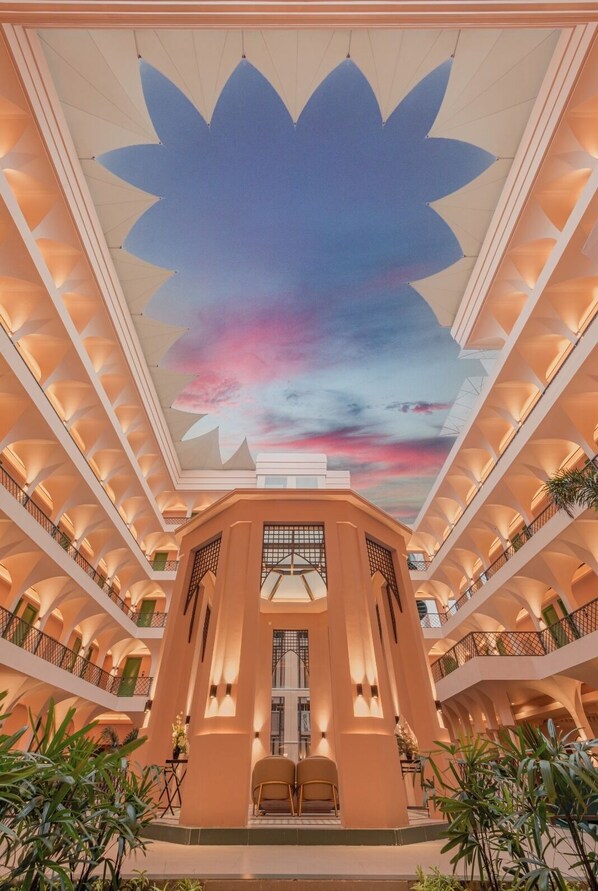 Ein mehrgeschossiges Atrium mit einer lotusblütenförmigen Decke, Balkonen und Innenpflanzen.