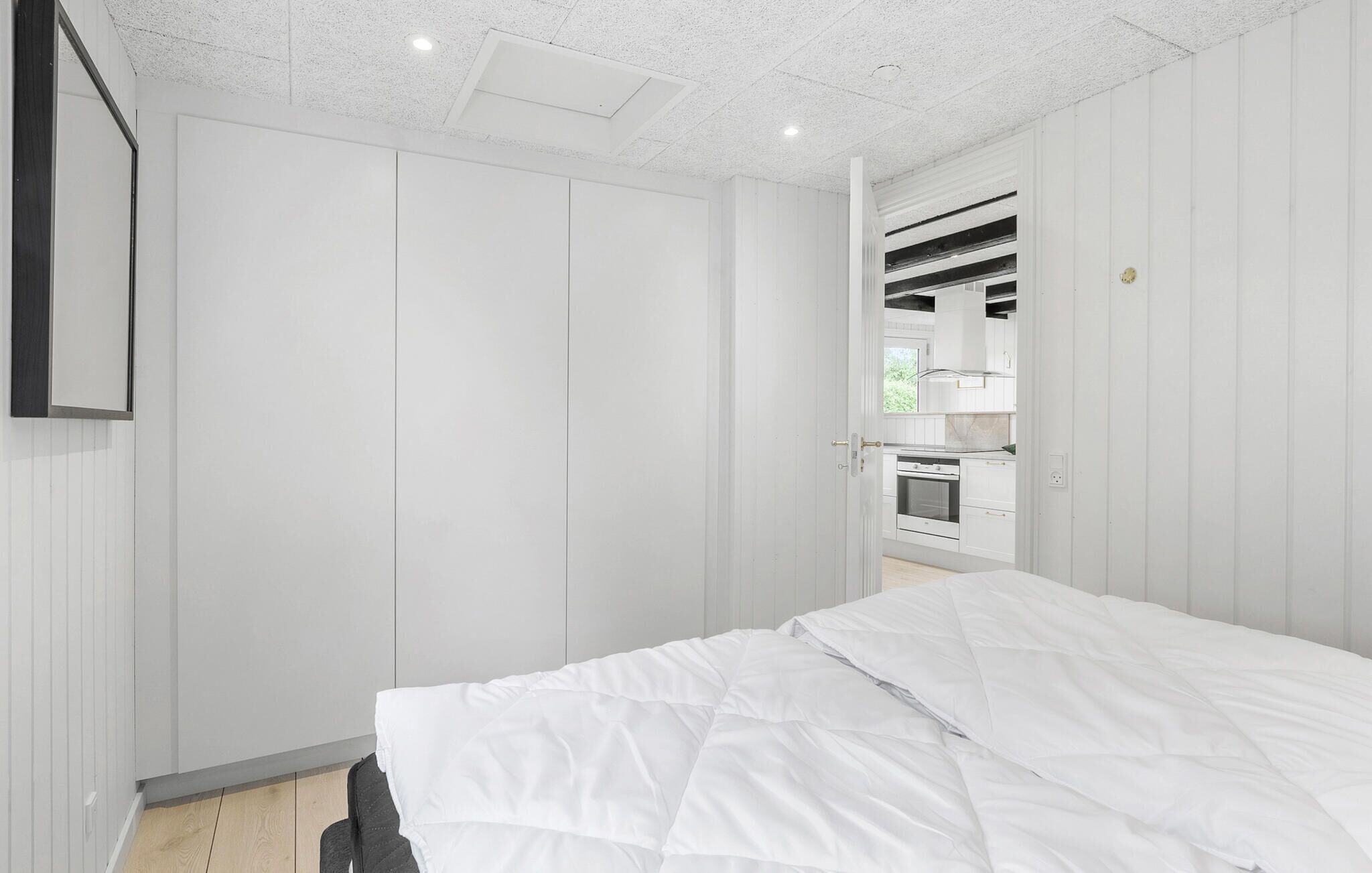 Une chambre avec un lit, une armoire et un coin cuisine.
