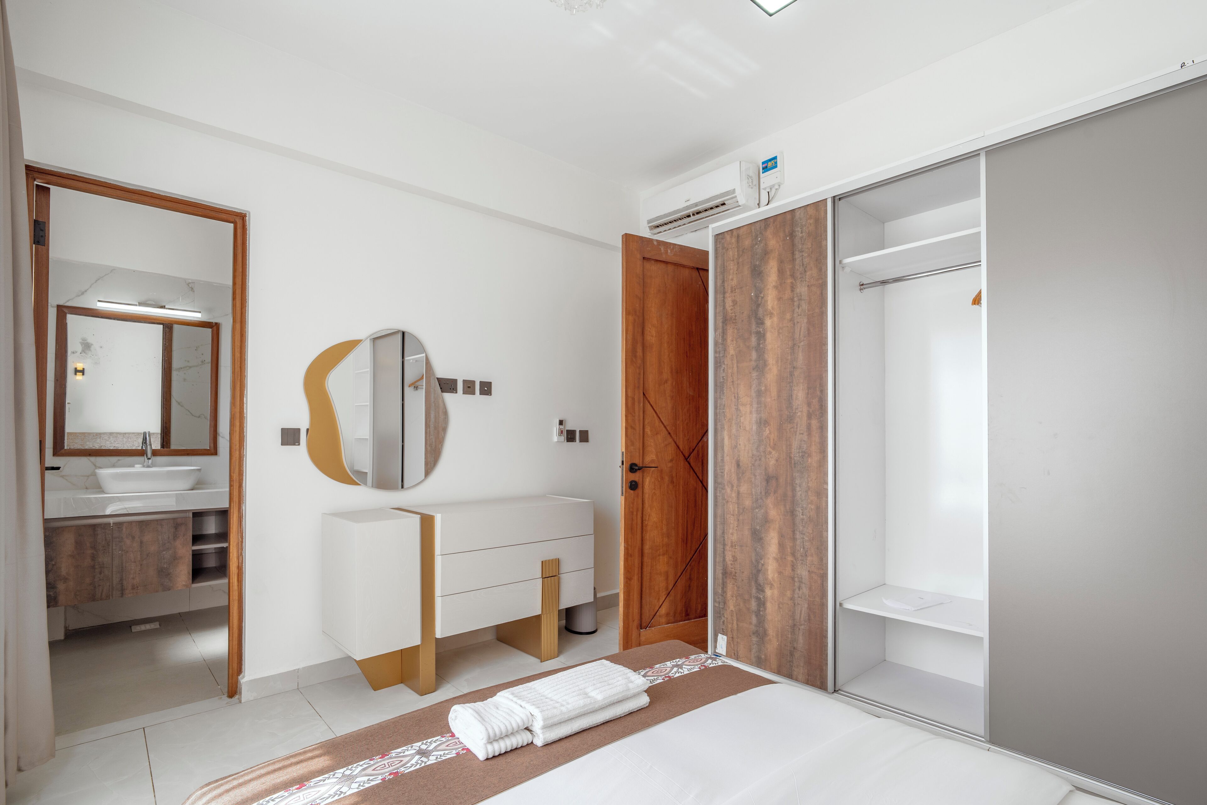 A modern bathroom with a large mirror, a sink, and a shower area.