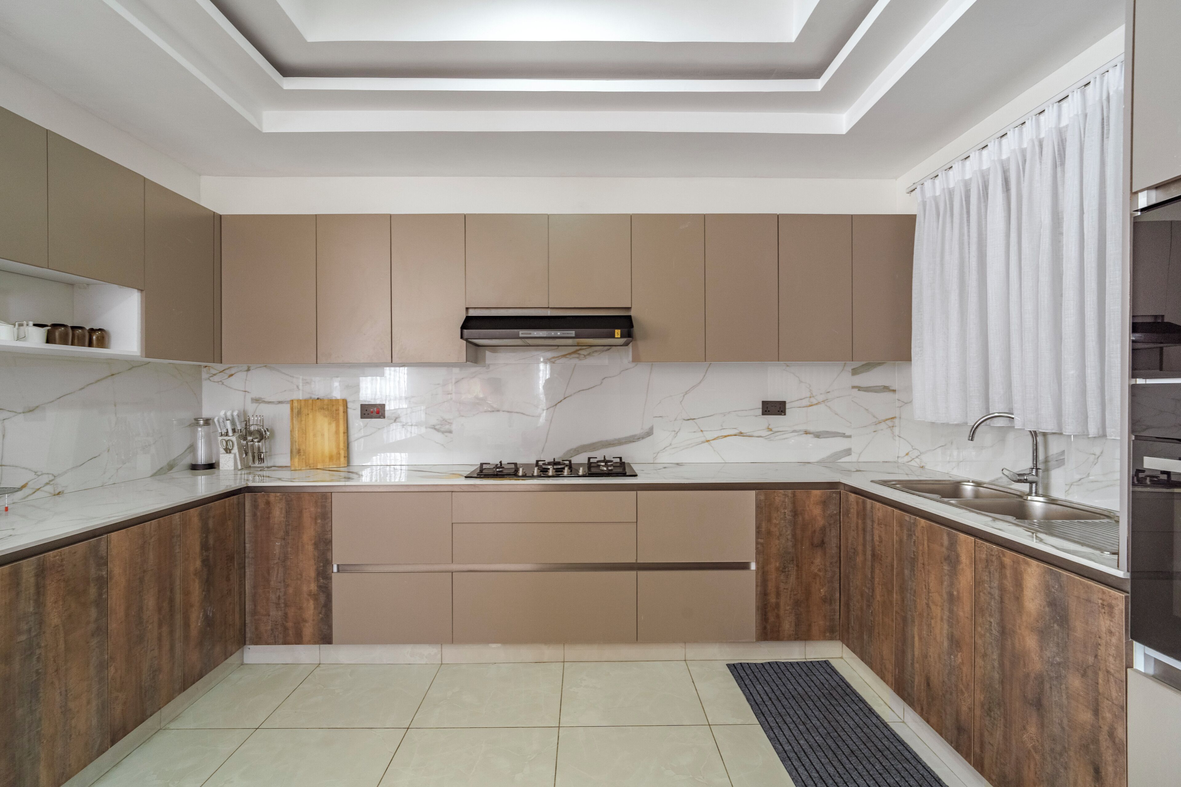 A modern kitchen with a central island, built-in cabinets, and a ceiling with recessed lighting.