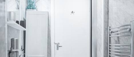 Een moderne badkamer met een witte deur, een ingebouwd wastafelmeubel en een handdoekhouder.