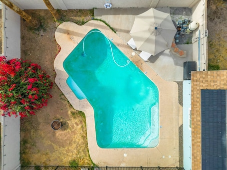 Alberca al aire libre, sombrillas en la alberca y camastros