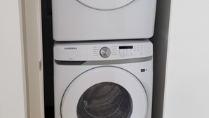 A laundry room with two stacked Samsung washing machines.
