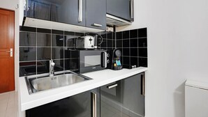 Una cucina moderna con forno a microonde, tostapane e macchina per il caffè sul bancone.