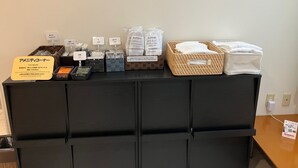 A hotel reception area with a black counter displaying amenities like toothbrushes, slippers, and tea. - Smile Hotel Yonezawa (Yonezawa)