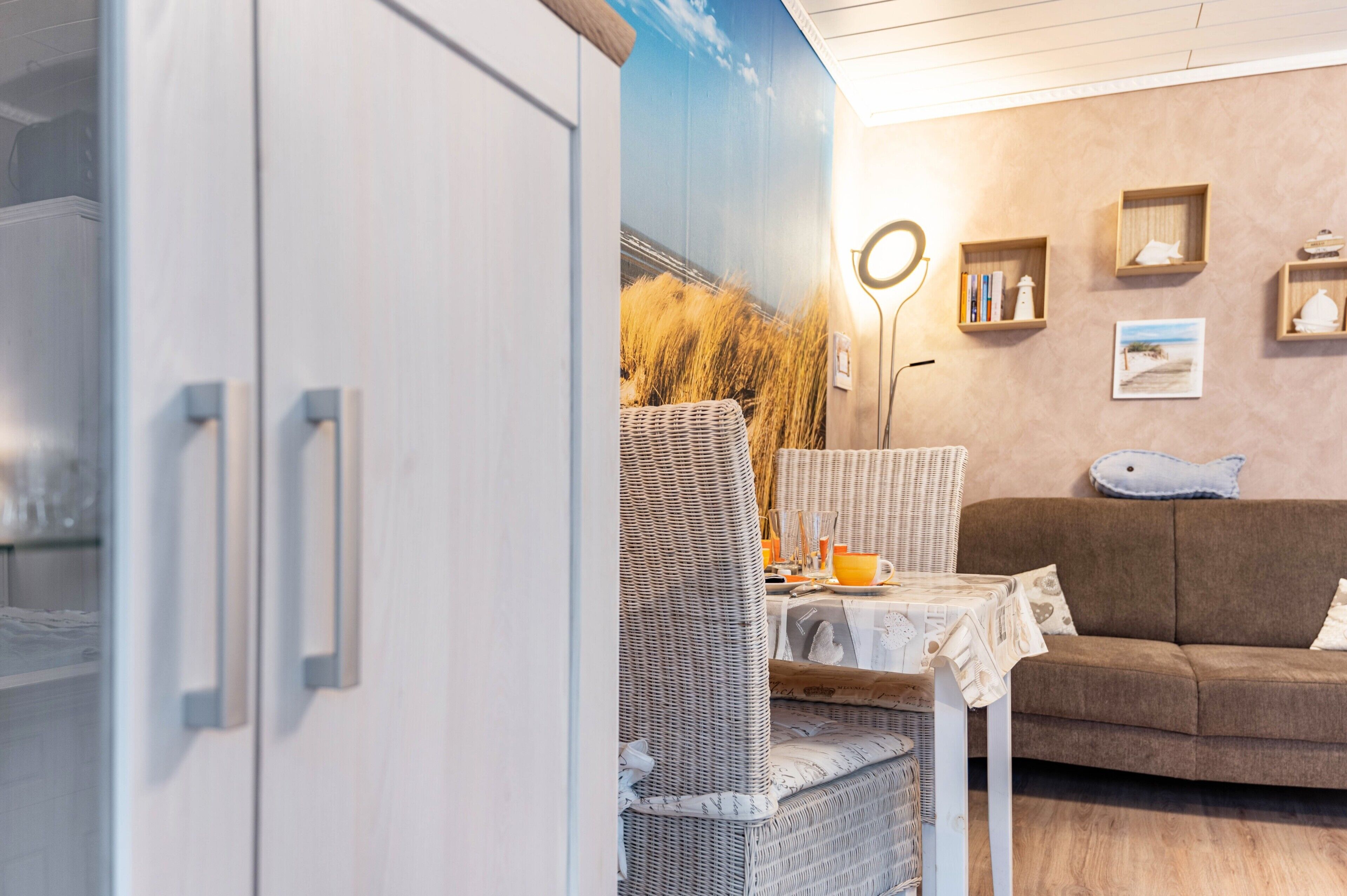 Een kamer met een eethoek, een bank en een muur met ingelijste foto's.